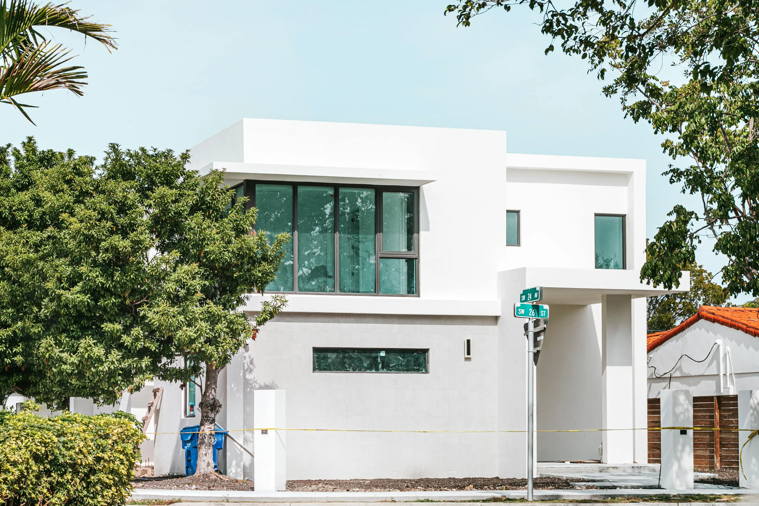 A modern white two-storey custom home with large windows